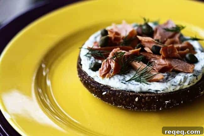 Lemon Dill Cream Cheese Recipe + Ultimate Breakfast Sandwich Guide 3 Lemon Dill Spreadable Cream Cheese on a black Russian bagel with smoked salmon and capers from Foodie with Family.