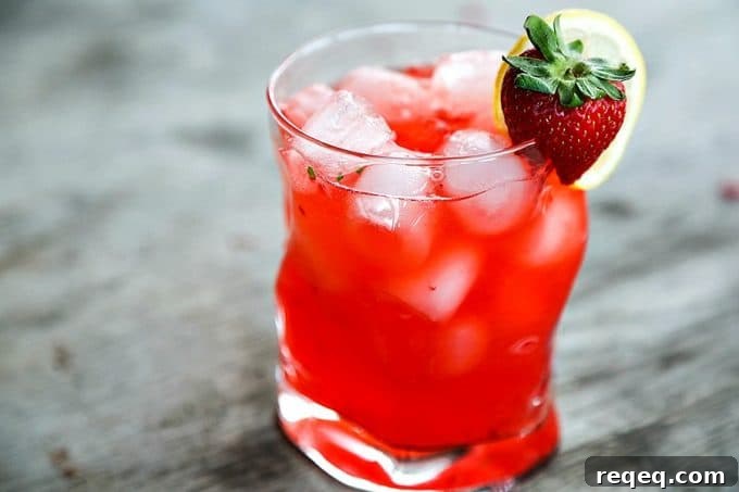 Strawberry Basil Lemonade Cocktail Recipe | Summer Boozy Drink 4 boozy strawberry basil lemonade, bormioli rocco sorgente highball glass, strawberry and lemon garnish, rustic wood table