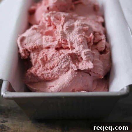 Creamy 3-Ingredient Strawberry Ice Cream Recipe 5 3-ingredient strawberry ice cream, parchment paper lined aluminum bread pan, rustic wooden table