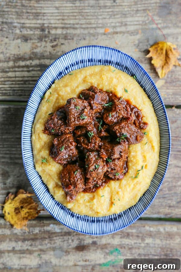 Peposo: Rustic Tuscan Braised Beef Stew Recipe 2 Tuscan Braised Beef in red wine sauce on creamy polenta in a blue and white dish.