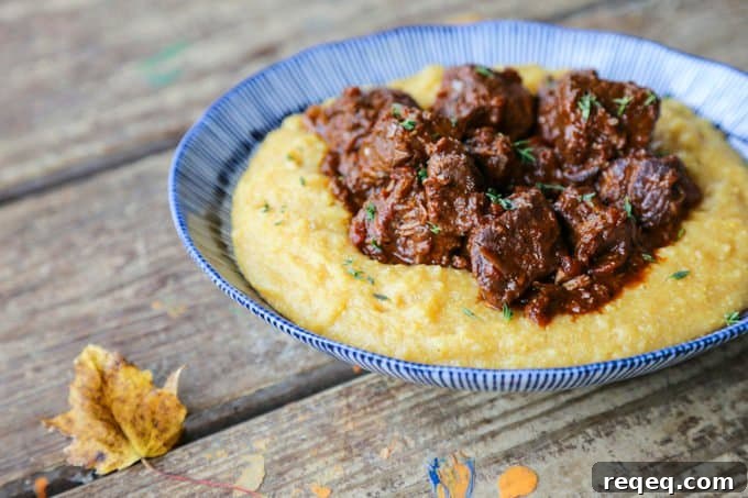 Peposo: Rustic Tuscan Braised Beef Stew Recipe 3 Tuscan Braised Beef in red wine sauce on creamy polenta in a blue and white dish.