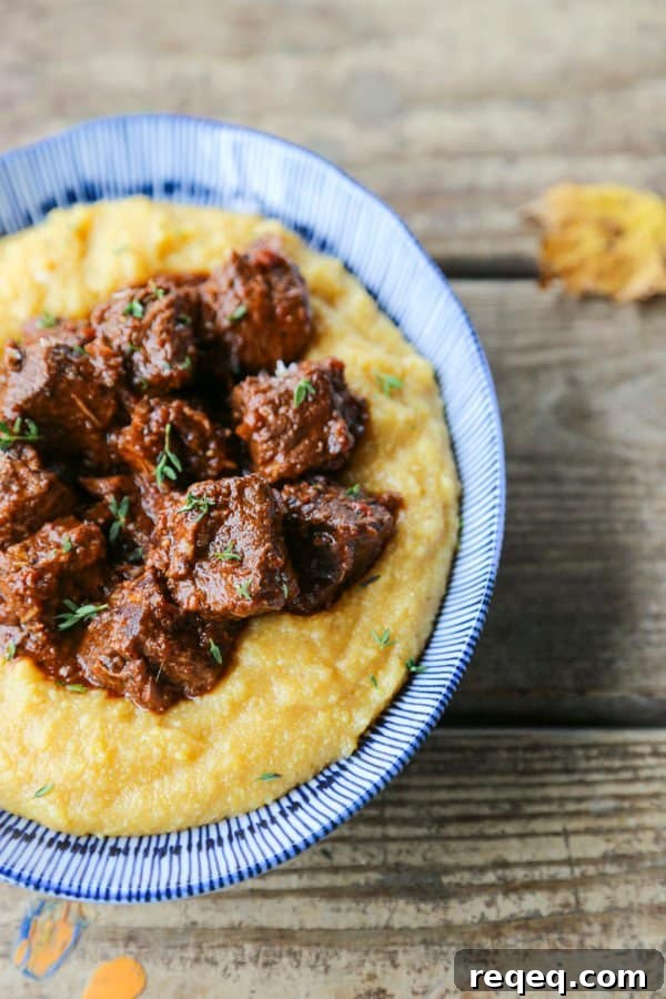 Peposo: Rustic Tuscan Braised Beef Stew Recipe 4 Tuscan Braised Beef in red wine sauce on creamy polenta in a blue and white dish.