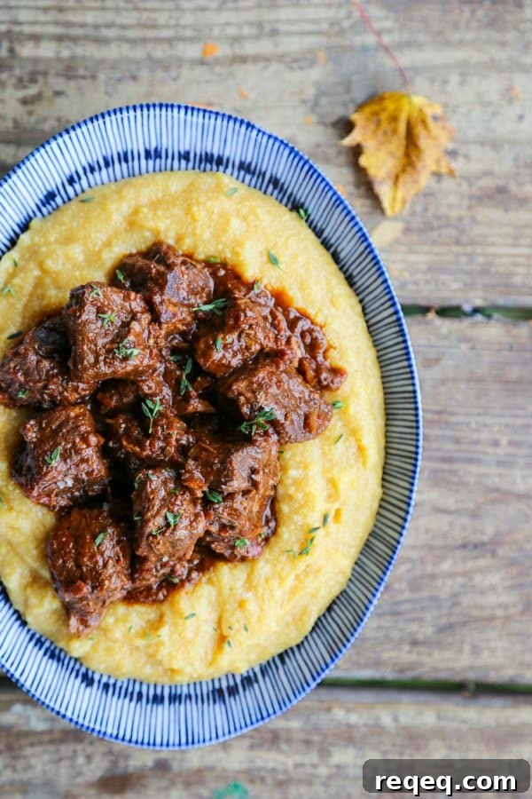 Peposo: Rustic Tuscan Braised Beef Stew Recipe 5 Tuscan Braised Beef in red wine sauce on creamy polenta in a blue and white dish.