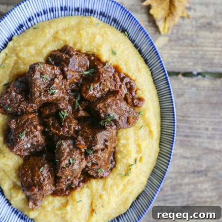 Peposo: Rustic Tuscan Braised Beef Stew Recipe 6 Tuscan Braised Beef in red wine sauce on creamy polenta in a blue and white dish.