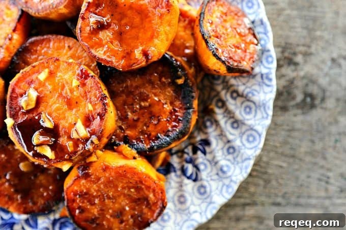 Creamy Baked Melting Sweet Potatoes with Brown Butter and Herbs 2 Melting Sweet Potatoes with sauce and garlic, roasted sweet potato rounds, caramelized, blue and white plate, on rustic wood table