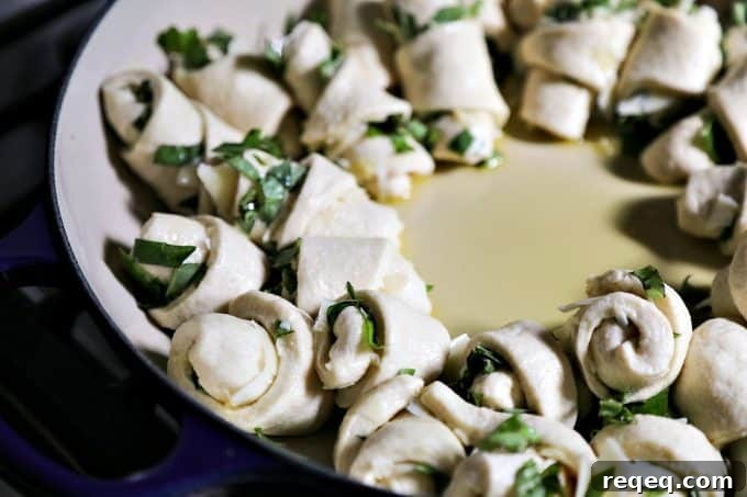 Garlic Basil Parmesan Rolls are my idea of a perfect bread. Perfect bread dough brushed with garlic infused olive oil and rolled around chopped garlic, fresh basil, and flakes of creamy, nutty Parmesan cheese then baked up to a beautiful, golden brown, tender-yet-chewy work of art.