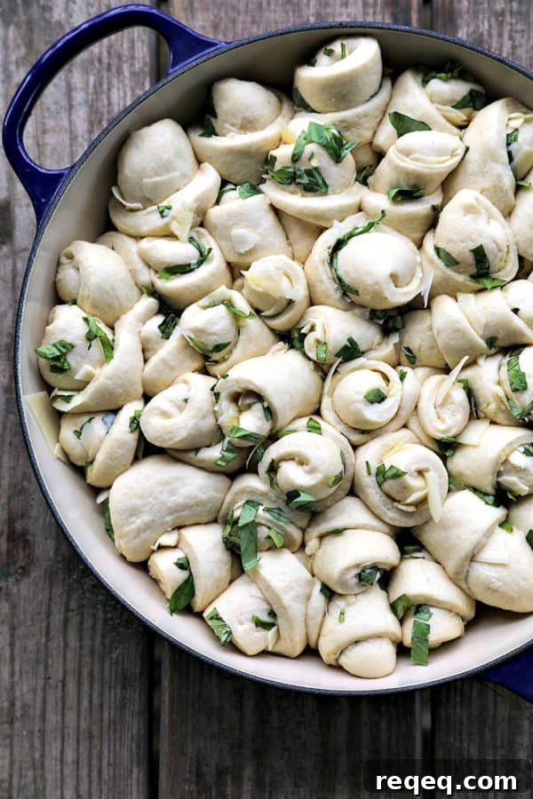 Garlic Basil Parmesan Rolls are my idea of a perfect bread. Perfect bread dough brushed with garlic infused olive oil and rolled around chopped garlic, fresh basil, and flakes of creamy, nutty Parmesan cheese then baked up to a beautiful, golden brown, tender-yet-chewy work of art.