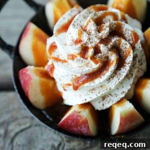 2-Minute Pull-Apart Caramel Apple Bites 8 2-Minute Pull Apart Caramel Apples , apple wedges, whipped cream topped with dripping caramel sauce and cinnamon, black and white cast enamel bowl with handles, wooden table