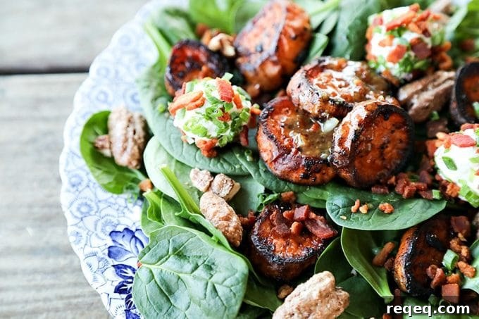 Melting Sweet Potato Salad: tender baby spinach salad with gorgeous, caramelized, deep orange melting sweet potato rounds, crumbled bacon, goat cheese crusted with more bacon and fresh chives, candied maple pecans, and an irresistible hot bacon vinaigrette dressing.