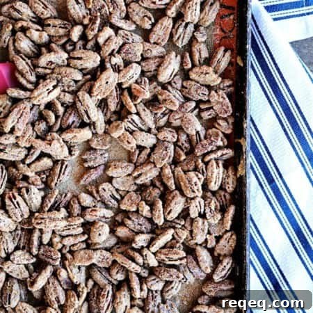 Maple Candied Pecans: Sweet Glazed Pecans Recipe for Snacking 4 Candied Maple Pecans on a silpat lined antique metal sheet pan, crisp blue and white cotton towel, wooden bench