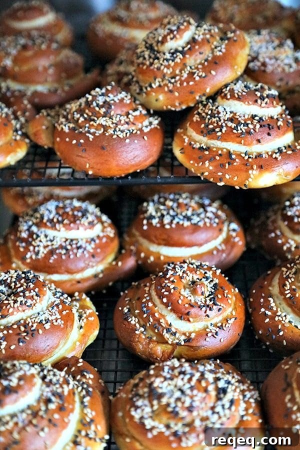 The most perfect soft pretzel rolls for sandwiches. Tender yet chewy, and substantial enough to hold up to any fillings. Topped with a delightful combination of sesame seeds and pretzel salt. Soft pretzel rolls, cooling rack