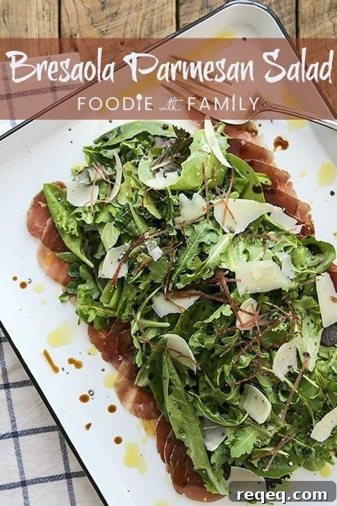 Bresaola and Parmesan Salad with Arugula and Lemon Dressing 6 Bresaola Parmesan Salad on white quarter sheet pan with cobalt blue rim, blue and white tea towel, antique fork, rustic wood tabletop, pinterest title banner
