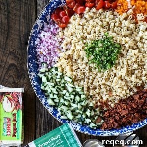 Tender, little ditalini, crunchy yellow and orange bell pepper, cucumber, crispy bacon crumbles, tiny cubes of Cheddar and pepper jack cheese, and minced fresh jalapeño pepper and chives in a creamy ranch dressing make this Spicy Bacon Cheddar Pasta Salad recipe scream summer!