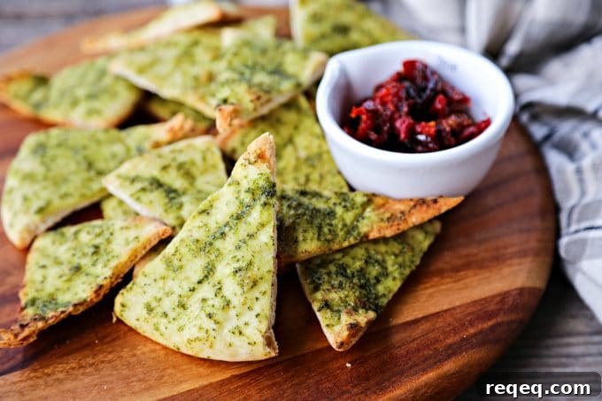 Crispy, crunchy, perfect pesto brushed homemade pita chips are as easy as cut, brush, bake and make a great snack or salad accompaniment.