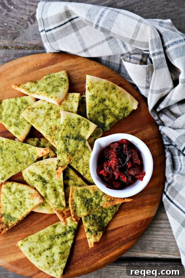 Crispy, crunchy, perfect pesto brushed homemade pita chips are as easy as cut, brush, bake and make a great snack or salad accompaniment.