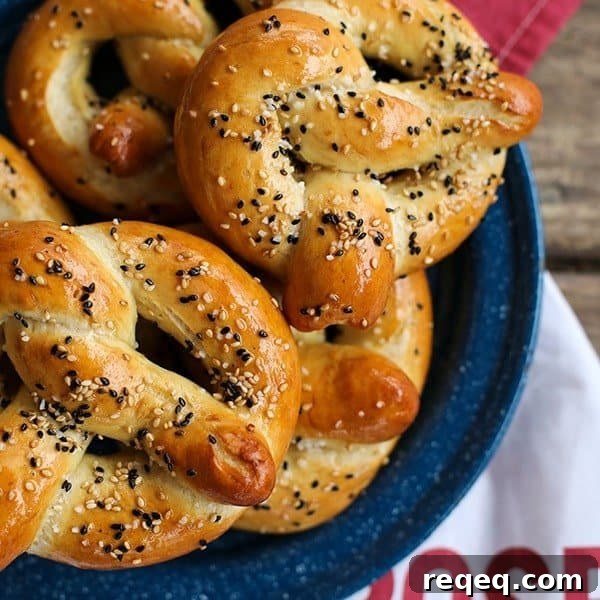 Sourdough soft pretzels in traditional shape, brushed with butter, black and white sesame seeds and kosher salt