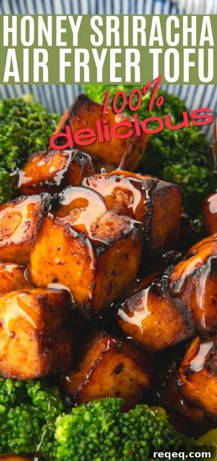 Honey Sriracha Crispy Tofu in the Air Fryer: Sticky & Crunchy 9 Golden brown cubes of crispy tofu drizzled with honey on broccoli, served on a blue and white striped oblong bowl.