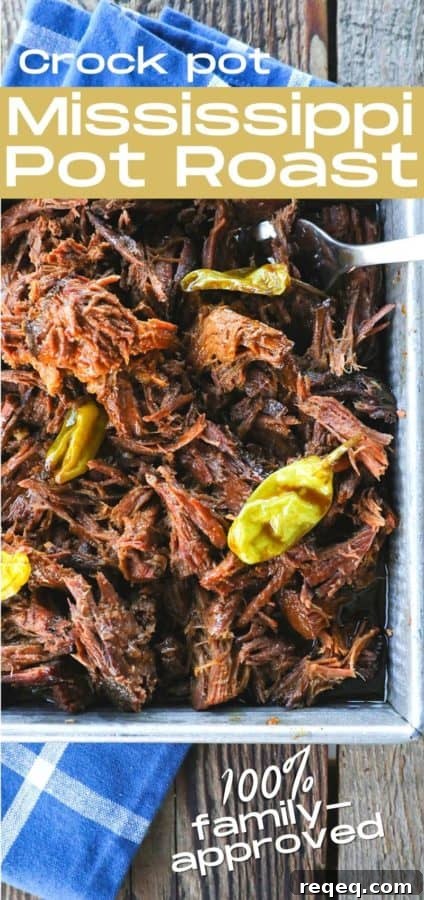 Mississippi Pot Roast Slow Cooker Recipe: Tender, Flavorful Roast 7 Shredded Crock Pot Mississippi Pot Roast in a square metal pan with whole pepperoncini and meat forks on a blue linen and wooden table.