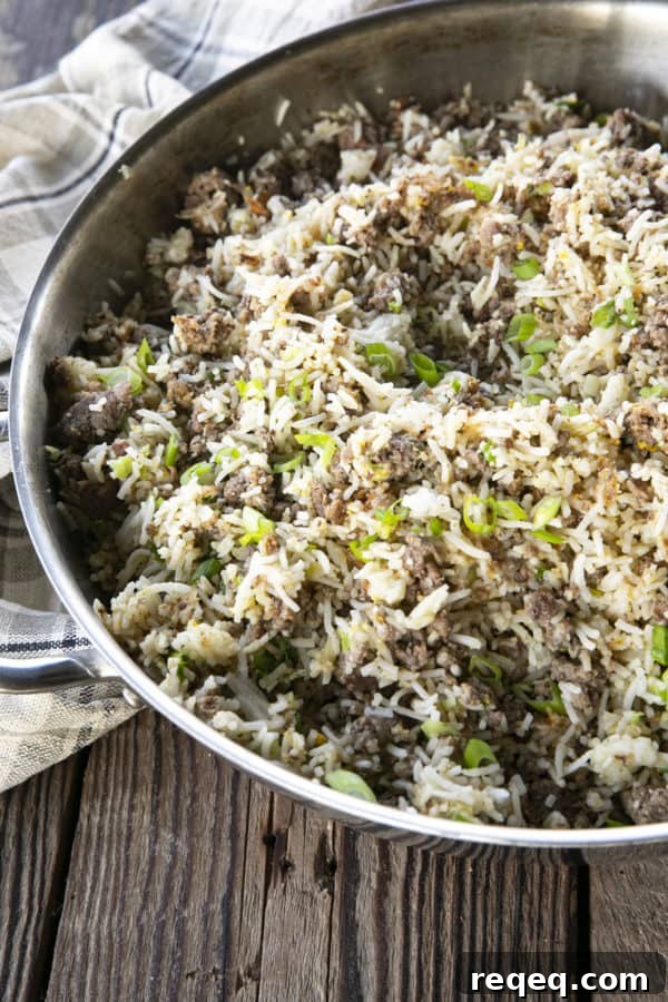 Savory Ground Beef Fried Rice Recipe for Quick Weeknight Meals 2 Ground Beef Fried Rice in a pan on a wooden table.