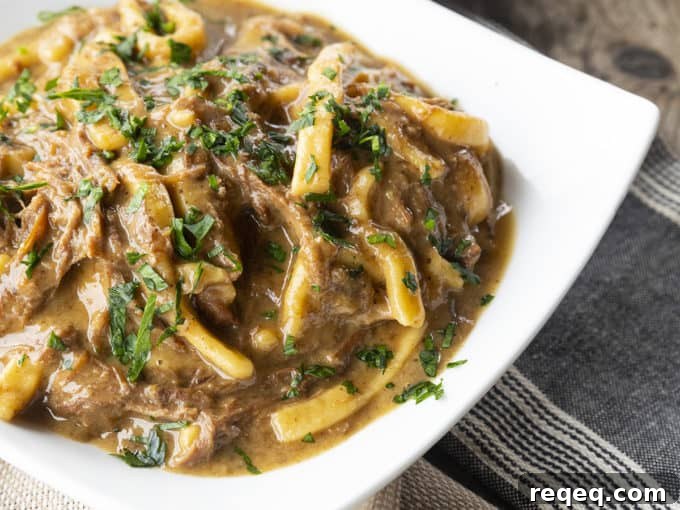Slow Cooker Beef and Noodles Recipe for Comforting Weeknight Meals 5 crock pot beef and noodles in a white square bowl on linens