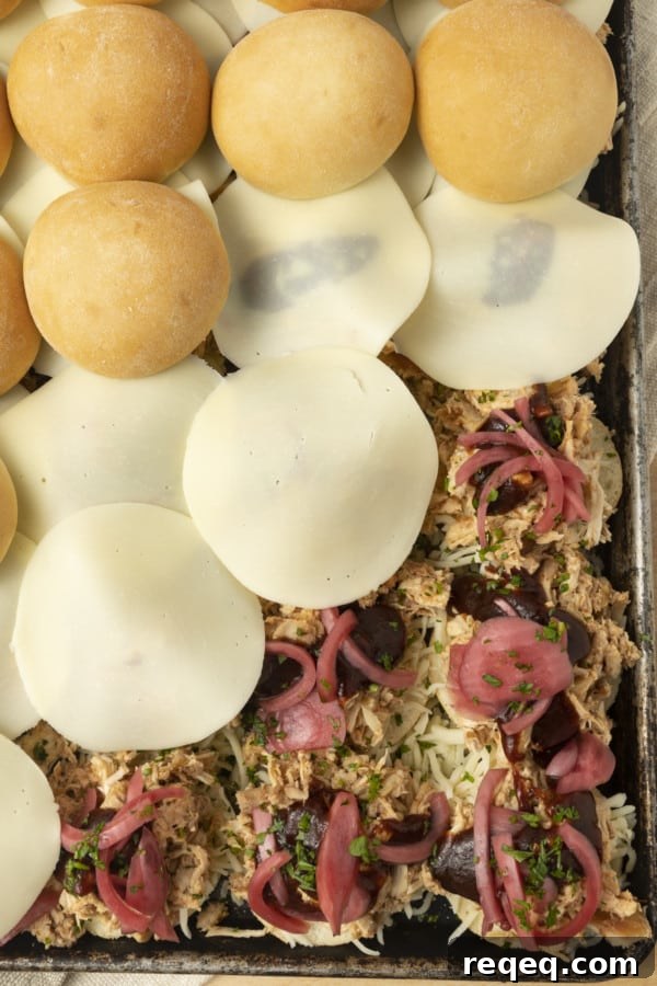 BBQ Chicken Sliders Recipe: Tangy Pulled Chicken Sandwiches 3 These easy BBQ Chicken Sliders make an easy weeknight meal and they're a perfect game day recipe, too! We're talking about pulled chicken tossed with barbecue sauce and topped with melted cheese, pickled onions, baked on soft white dinner rolls and brushed with garlic butter. Just see if you can resist them!