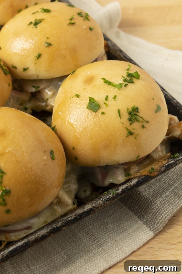 BBQ Chicken Sliders Recipe: Tangy Pulled Chicken Sandwiches 4 These easy BBQ Chicken Sliders make an easy weeknight meal and they're a perfect game day recipe, too! We're talking about pulled chicken tossed with barbecue sauce and topped with melted cheese, pickled onions, baked on soft white dinner rolls and brushed with garlic butter. Just see if you can resist them!