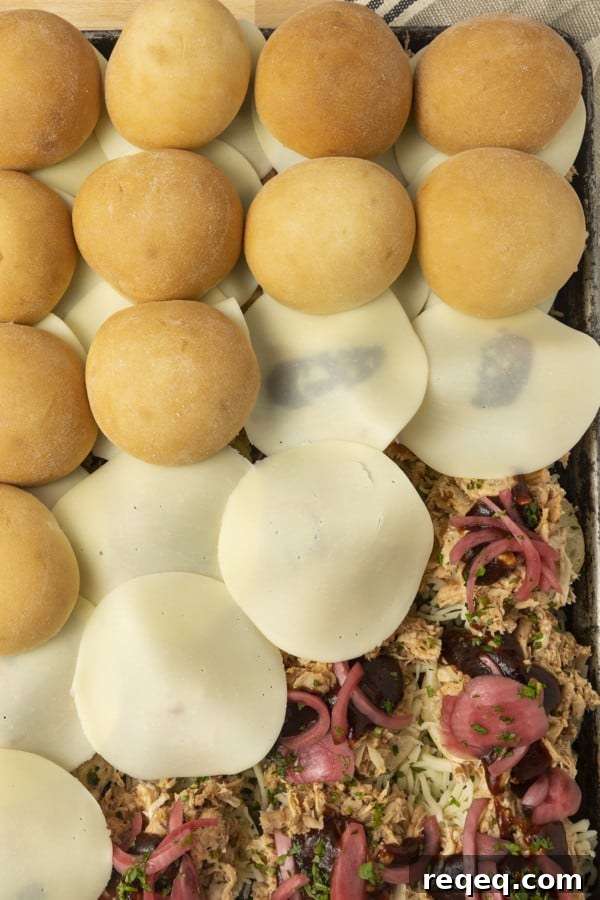 BBQ Chicken Sliders Recipe: Tangy Pulled Chicken Sandwiches 5 These easy BBQ Chicken Sliders make an easy weeknight meal and they're a perfect game day recipe, too! We're talking about pulled chicken tossed with barbecue sauce and topped with melted cheese, pickled onions, baked on soft white dinner rolls and brushed with garlic butter. Just see if you can resist them!