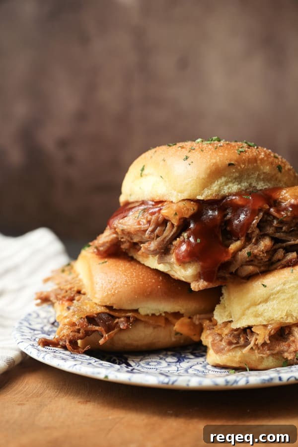 Smoky Pulled Pork Sliders with Tangy BBQ Sauce 2 Easy Pulled Pork Sliders: Pillowy rolls filled with delicious, mouth-watering, tender pulled pork, bbq sauce, and cheese are brushed with melted butter, garlic, and herbs, then baked to toasty, melty perfection. They’re like the little black dress of the sandwich world and perfect for every occasion. Bonus: They're done in 30 minutes from start to finish!