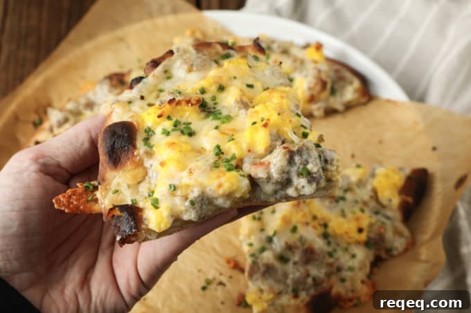 Close up of breakfast pizza topped with eggs and sausage gravy.