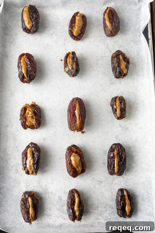 Chocolate-Covered Dates: Simple Recipe for Decadent Treats 5 almond stuffed dates with sea salt on parchment lined sheet pan