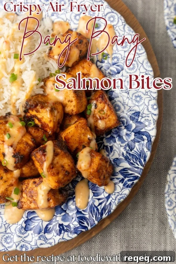Crispy Bang Bang Salmon Bites Recipe for Spicy Sweet Salmon Bites 8 crispy air fryer bang bang salmon bites drizzled with sauce served with ice on a blue and white floral plate with text overlay describing the photo