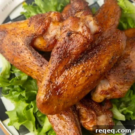 Smoked Turkey Wings Recipe: Tender, Flavorful and Juicy 7 smoked turkey wings on top of a black and white checked plate with lettuce