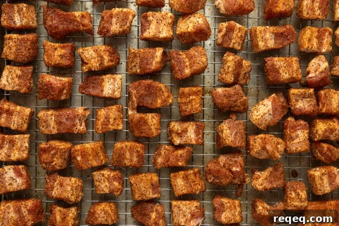 Crispy Pork Belly Bites Recipe: Savory Bite-Size Pork Treats 4 A cooling rack filled with pieces of meat.
