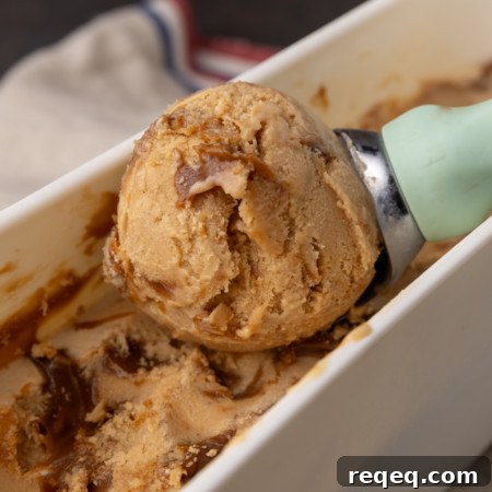 Creamy Dulce de Leche Ice Cream Recipe – Homemade Argentine Flavor 6 A scoop of ice cream is being scooped into a bowl.