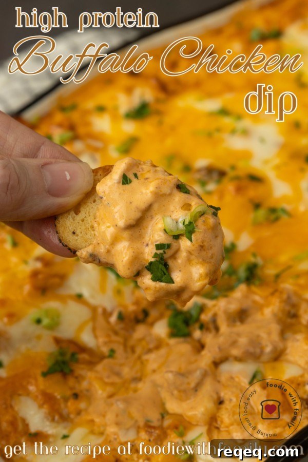 High-Protein Buffalo Chicken Dip Recipe for Game Day 7 A hand holding a piece of buffalo chicken dip.