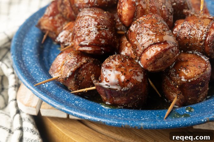 air fryer kielbasa bites wrapped with bacon drizzled with honey on a blue plate