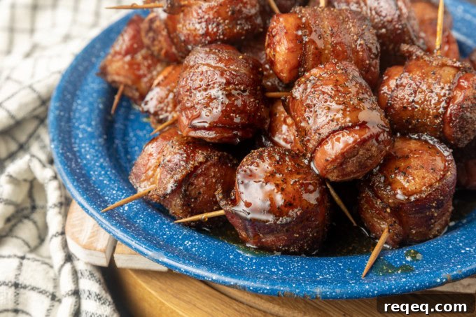 air fryer kielbasa bites wrapped with bacon drizzled with honey on a blue plate
