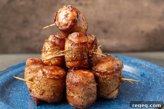 air fryer kielbasa bites wrapped with bacon drizzled with honey on a blue plate
