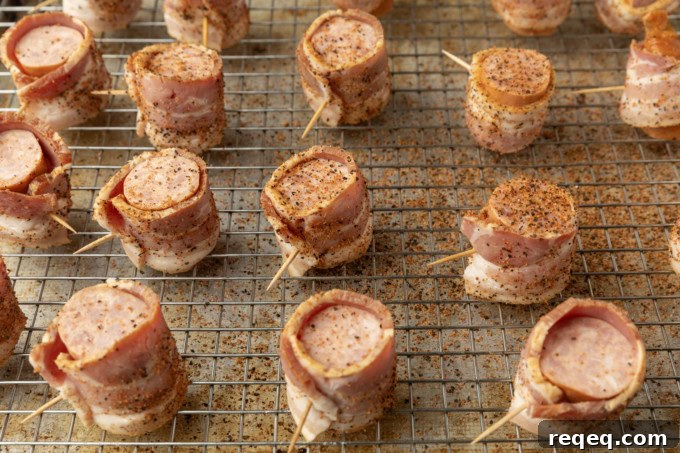 seasoned kielbasa in air fryer bites wrapped with bacon on a cooling rack