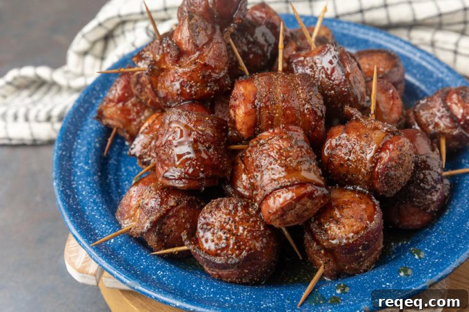 air fryer kielbasa bites wrapped with bacon drizzled with honey on a blue plate
