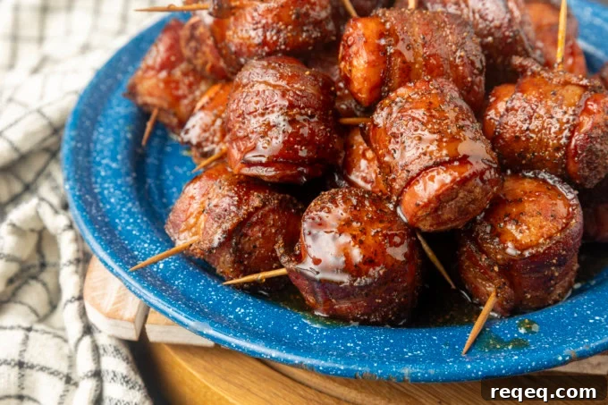 air fryer kielbasa bites wrapped with bacon drizzled with honey on a blue plate