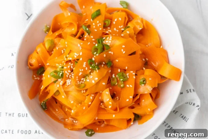 Crisp Asian Carrot Salad with Sesame Ginger Dressing 2 carrot ribbon salad in a white bowl