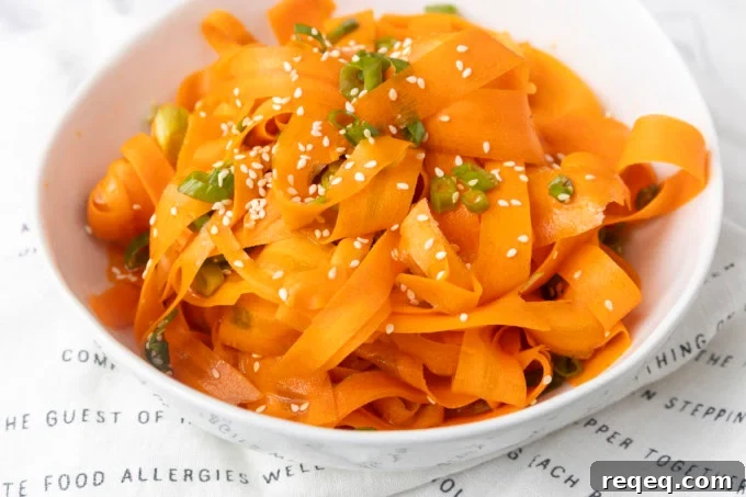 Crisp Asian Carrot Salad with Sesame Ginger Dressing 3 carrot ribbon salad in a white bowl