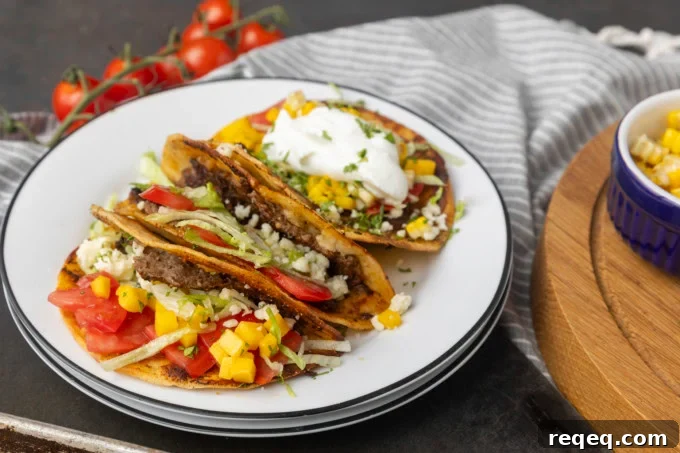 smash tacos on stacked plates with toppings in bowls