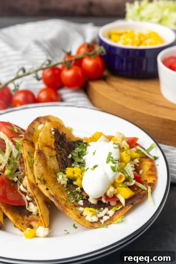 smash tacos on stacked plates with toppings in bowls