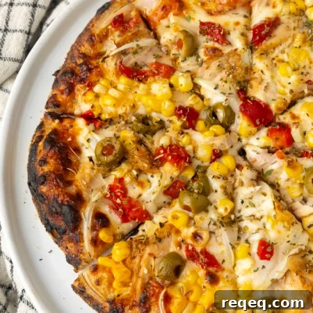 tuna pizza with corn, olives, onions, and roasted red peppers