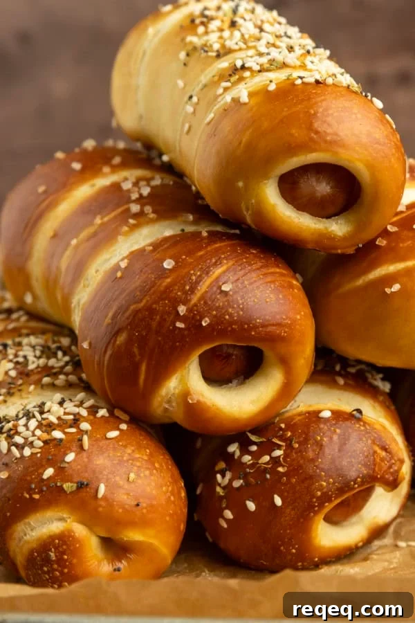 How to Make Pretzel Dogs at Home: Soft, Chewy Snack Recipe 5 pretzel dogs on parchment paper on a pan with a variety of dipsa