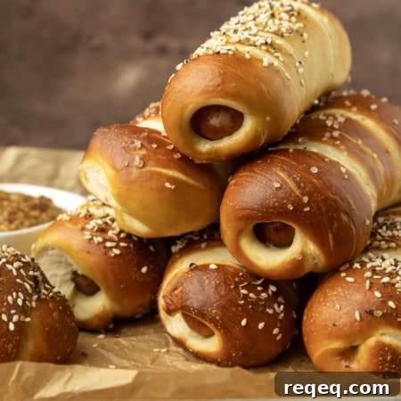 How to Make Pretzel Dogs at Home: Soft, Chewy Snack Recipe 6 pretzel dogs on parchment paper on a pan with a variety of dipsa