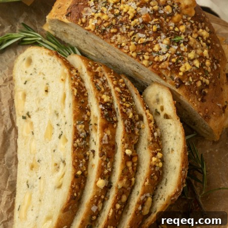 Rosemary Parmesan Artisan Bread Recipe for Crispy Crust and Flavor 10 partially sliced one hour rosemary parmesan bread on parchment paper