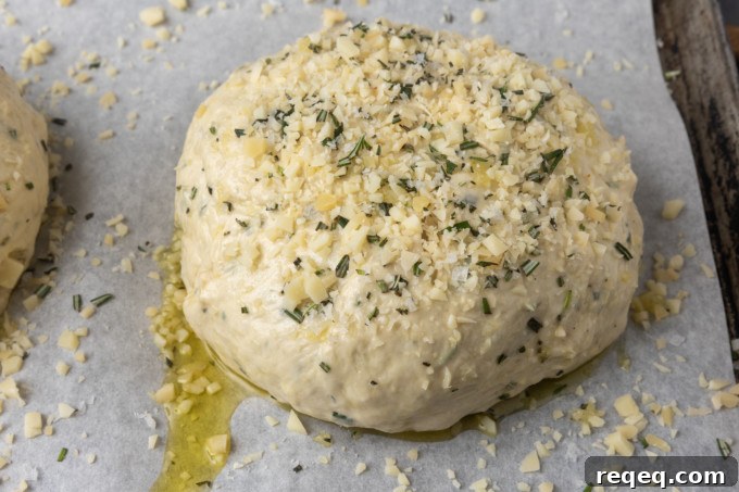 Rosemary Parmesan Artisan Bread Recipe for Crispy Crust and Flavor 5 Unbaked Rosemary Parmesan Garlic Bread on a parchment lined sheet pan